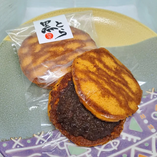 お菓子のご紹介《黒とら》

沖縄県産の黒砂糖をふんだんに使用したコク深い皮に
十勝産小豆のつぶ餡を挟んだどら焼きです🍵

30年以上ご愛顧いただいている当店の人気商品です！

 #藤宮製菓
 #岩槻